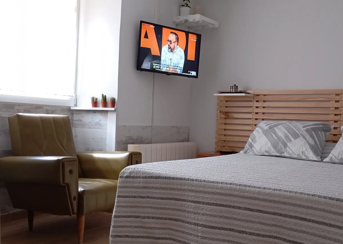 Dormitorio con cama doble y televisión