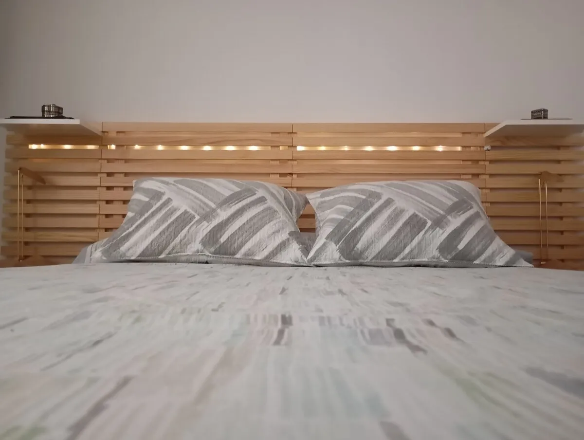 Dormitorio de Casa Juana con cabecero de madera y luz natural
